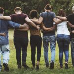 Group of friends huddle in rear view together